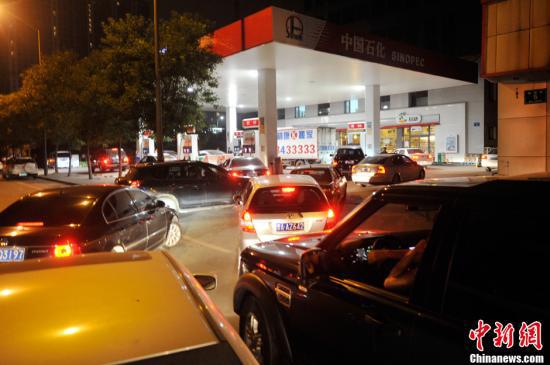 资料图：山西太原一加油站内，私家车主排队加油。中新社发 韦亮 摄